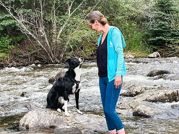 Kathleen and dog looking at each other in Boulder Creek, Boulder, CO